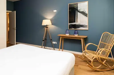 a bedroom with a bed and a chair and a lamp at VIVA Size Flats Clérigos in Porto