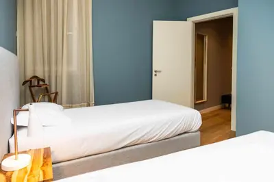 two beds in a room with blue walls at VIVA Size Flats Clérigos in Porto