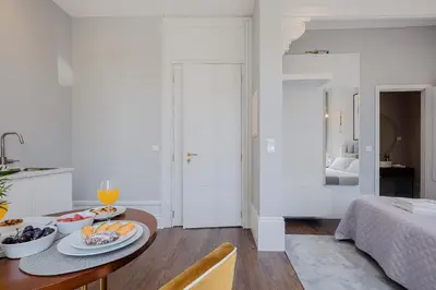 a kitchen and living room with a table with fruit on it at Plaza-Charming GuestHouse in Porto