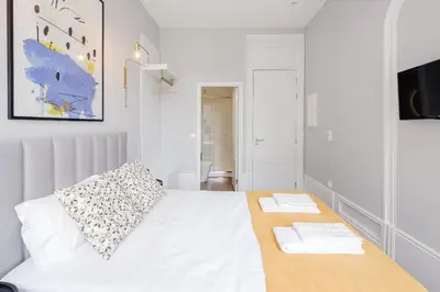 a bedroom with a white bed with two towels on it at Plaza-Charming GuestHouse in Porto