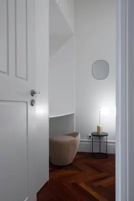 a white room with a chair and a table at Trindade Premium Apartments in Porto