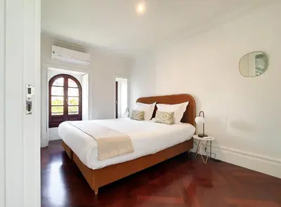 a white bedroom with a large bed and a window at Trindade Premium Apartments in Porto