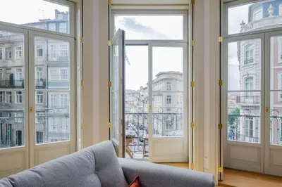 a living room with large windows and a couch at BOUTIQUE Rentals-Kihara’s Ribeira Apt with great views in Porto