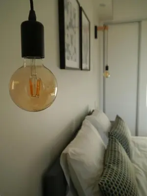 a glass light hanging over a bed in a room at Chez Moi Bolhão in Porto
