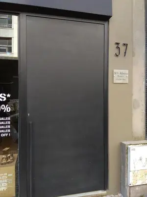 a black door with the number on a building at Chez Moi Bolhão in Porto