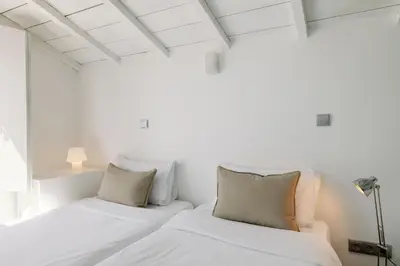 a white bedroom with two beds and a window at Fine Arts Studios by Olala Homes in Porto