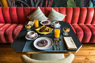 a table with plates of food and drinks on a couch at Menina Colina Guesthouse in Porto