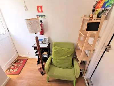 a small kitchen with a blue chair and a table at St. Johns Alley of Poetry and Imaginary Cats in Porto