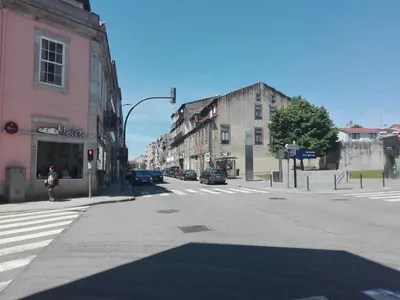 an empty city street with cars on the road at St. Johns Alley of Poetry and Imaginary Cats in Porto