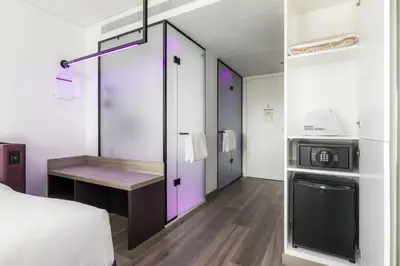 a room with a bed and a desk and a microwave at YOTEL Porto in Porto