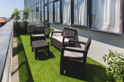a row of chairs sitting on the grass on a balcony at Aposentus - Skyline Porto in Porto