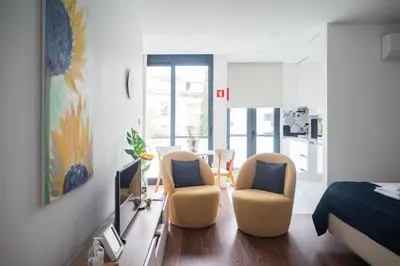 a living room with two chairs and a bed at Sunflower Luxury Loft w AC Downtown and Metro in Porto