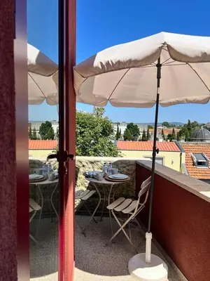 an umbrella on a balcony with tables and chairs at Nomad's Fine Arts Collection in Porto