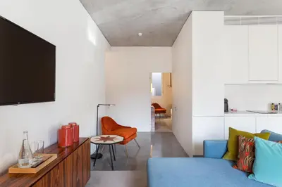 a living room with a blue couch and a tv at S.Bento Residences in Porto