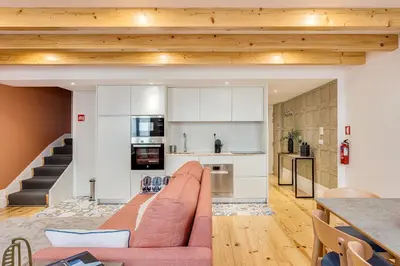 a living room with a couch and a kitchen at Hopstays Oporto Tiles 2 - City Center Duplex in Porto