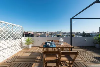 a patio with a table and chairs on a balcony at Oporto Dinis Apartment - Rooftop in Porto