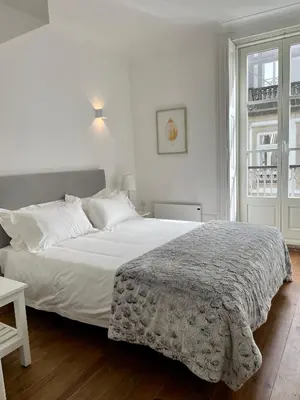 a white bed in a white bedroom with a window at Santa Catarina Guest House (Porto city center) in Porto