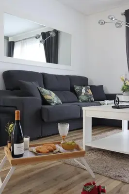 a living room with a blue couch and a table with food and wine at Bruval Premium Apartments - Gaia in Vila Nova de Gaia