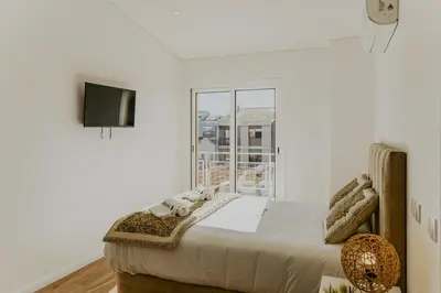 a white bedroom with a bed and a window at Bruval Premium Apartments - Gaia in Vila Nova de Gaia