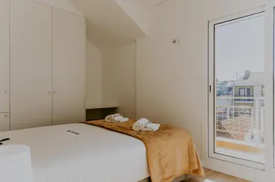 a white bedroom with a bed and a window at Bruval Premium Apartments - Gaia in Vila Nova de Gaia