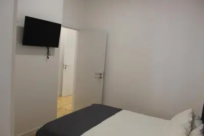 a bedroom with a bed and a flat screen tv at Oporto Cool - Praça da Batalha in Porto