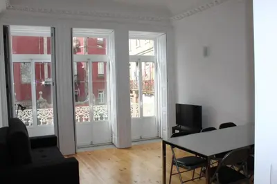a living room with doors and a table with chairs at Oporto Cool - Praça da Batalha in Porto