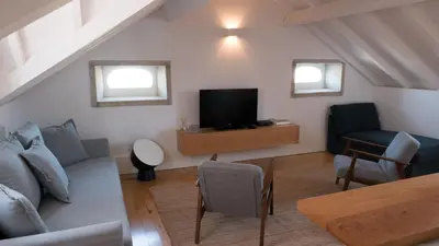 a living room with a couch and a tv at APOSENTUS - Architect and design apartment in Porto