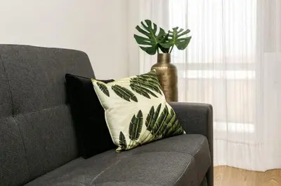 a couch with a pillow and a vase with a plant at APOSENTUS - Elegant Functionality Porto Downtown in Porto
