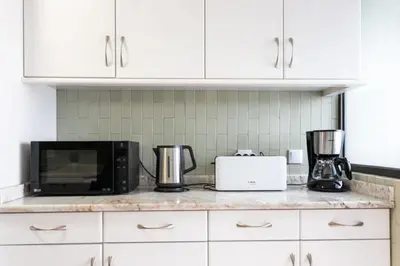 a kitchen counter with a microwave and a toaster oven at APOSENTUS - Elegant Functionality Porto Downtown in Porto