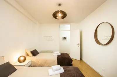 a bedroom with two beds and a mirror at APOSENTUS - Elegant Functionality Porto Downtown in Porto