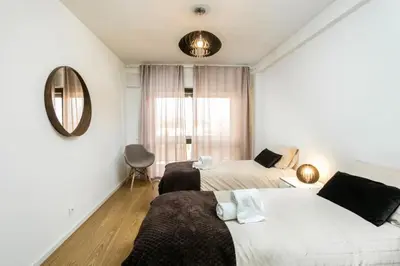 a bedroom with two beds and a mirror at APOSENTUS - Elegant Functionality Porto Downtown in Porto