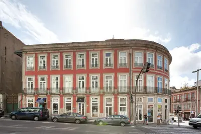 a red brick building with cars parked in front of it at Esmeralda Apartment by Cozy Stay in Porto