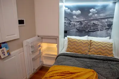 a bedroom with a bed with a painting on the wall at lita’s House Oporto Bainharia in Porto