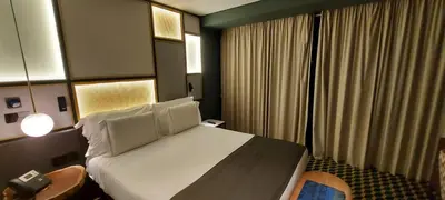 a hotel room with a large bed with white sheets at The Convo Porto Hotel & Apartments in Porto