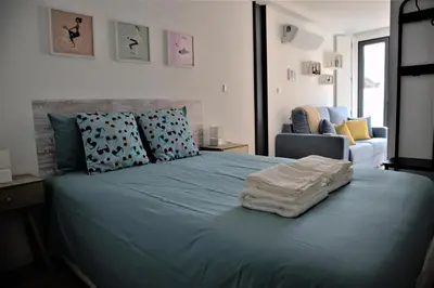 a bedroom with a blue bed with towels on it at NEW! Colorful and central (9 min-walk to main station) in Porto