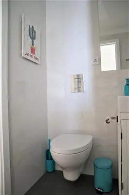 a bathroom with a toilet and a picture of a cactus at NEW! Colorful and central (9 min-walk to main station) in Porto