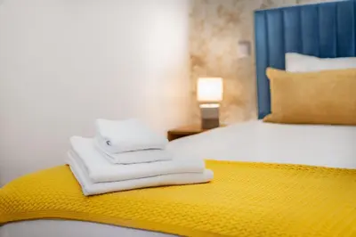 a pile of towels sitting on a bed in a room at Low Cost Parking - Private Garden - Almada 392 in Porto