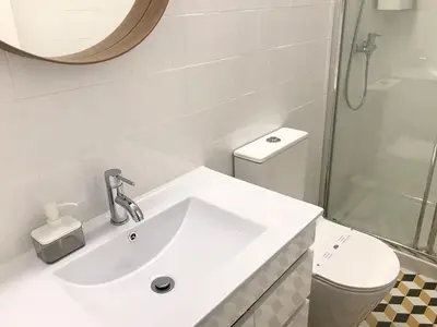a white bathroom with a sink and a toilet at Low Cost Parking - Private Garden - Almada 392 in Porto