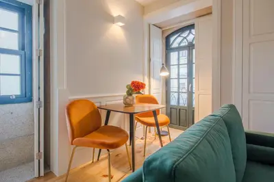 a living room with a table and chairs and a couch at Barão Oporto Apartments in Porto