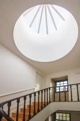 a large chandelier hangs from the ceiling of a staircase at Barão Oporto Apartments in Porto