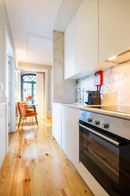 a kitchen with white cabinets and a stove top oven at Barão Oporto Apartments in Porto