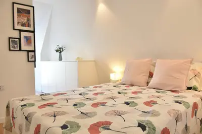 a bedroom with two beds and a large window at Sunny Penthouse whith balcony 9min walk main station in Porto