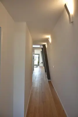 an empty hallway with white walls and wood floors at Sunny Penthouse whith balcony 9min walk main station in Porto
