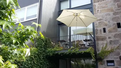 a balcony with an umbrella and chairs on it at Casa 45 Porto in Porto