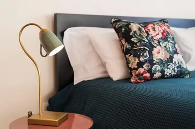 a bed with a pillow and a lamp on a table at LovelyStay - Homey Feeling Flat w/ Free Parking in Porto
