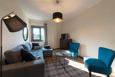 a living room with a couch and two blue chairs at LovelyStay - Homey Feeling Flat w/ Free Parking in Porto