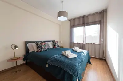 a bedroom with a bed with a blue blanket and a window at LovelyStay - Homey Feeling Flat w/ Free Parking in Porto