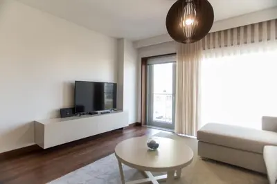 a living room with a couch and a tv and a table at Afurada premium apartment by Porto City Hosts in Vila Nova de Gaia