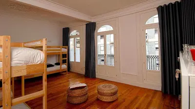 a bedroom with two bunk beds and two windows at So Cool Hostel Porto in Porto