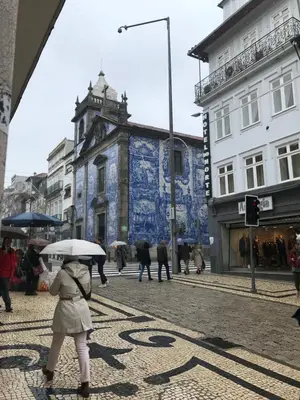 a woman walking down a street with an umbrella at City Heart Place 1 in Porto